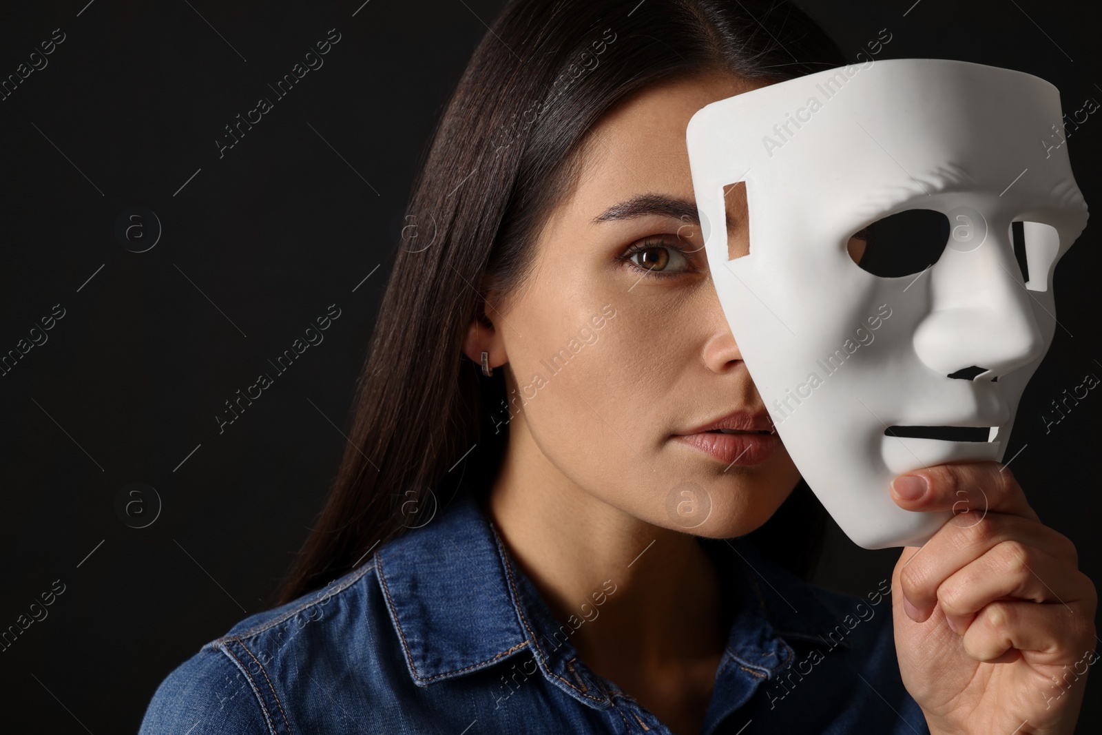 Photo of Multiple personality concept. Woman with mask on black background