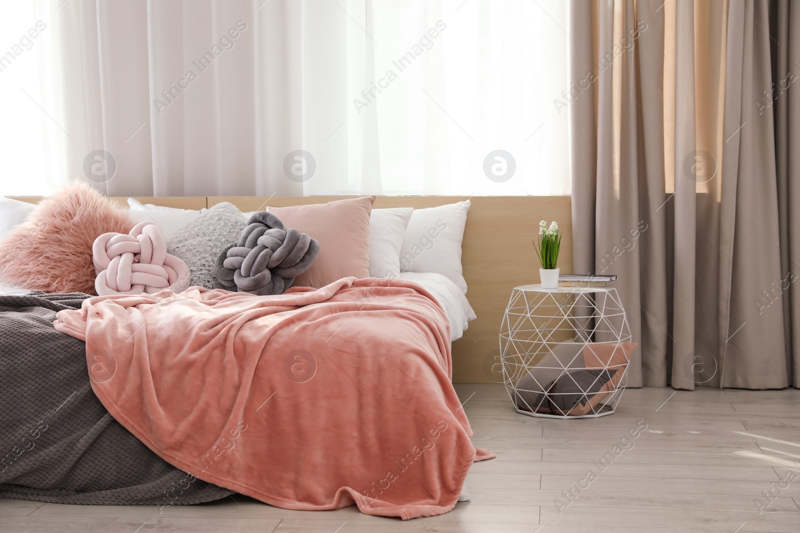 Photo of Comfortable bed with pillows and plaid in modern room interior