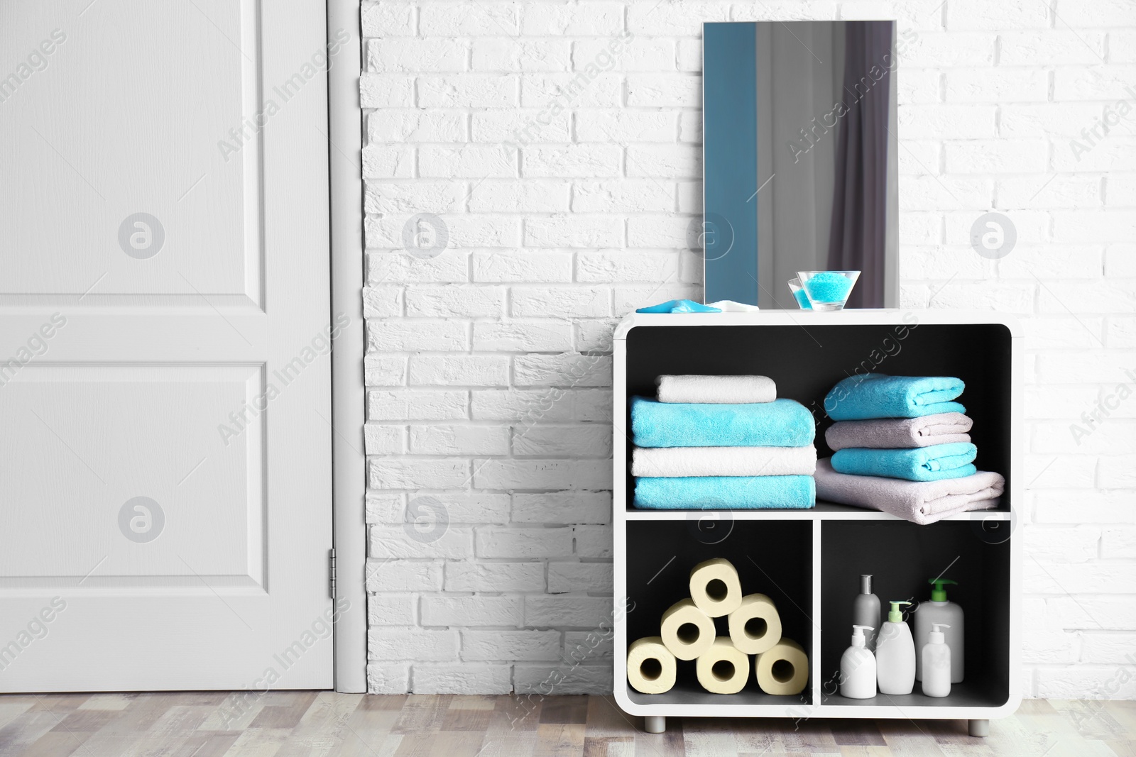 Photo of Clean towels and cosmetics in bathroom