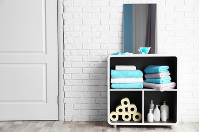 Photo of Clean towels and cosmetics in bathroom