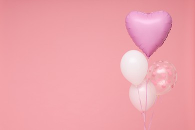 Photo of Bunch of heart and round shaped balloons on pink background, space for text. Birthday party