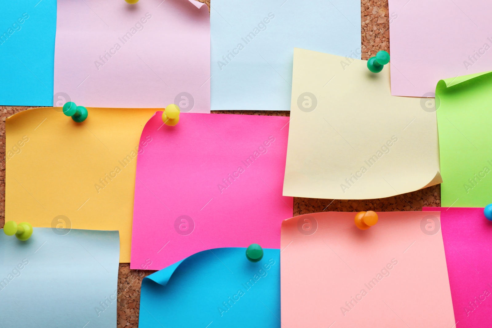 Photo of Many empty colorful notes pinned to cork board