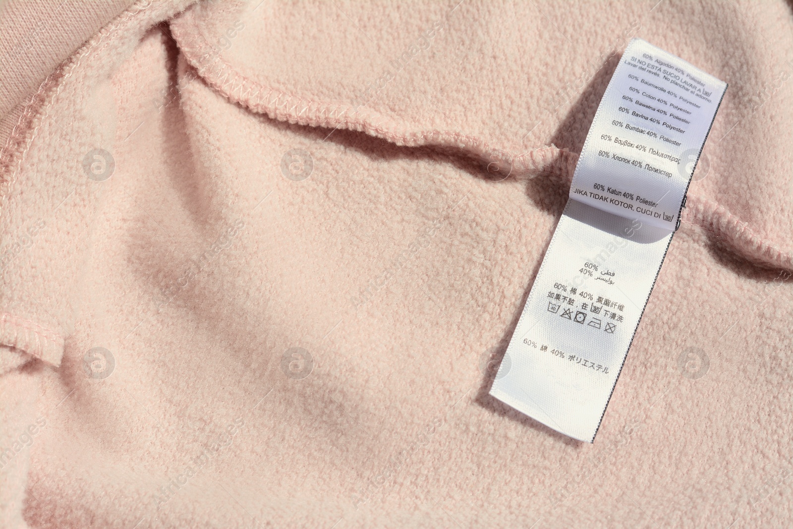 Photo of Clothing label on beige garment, closeup. Space for text