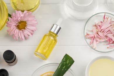 Flat lay composition with bottle of cosmetic oil on white wooden table