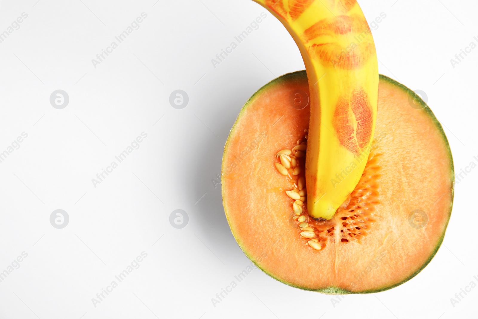 Photo of Fresh melon and banana with red lipstick marks on white background, top view. Sex concept