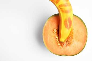 Photo of Fresh melon and banana with red lipstick marks on white background, top view. Sex concept