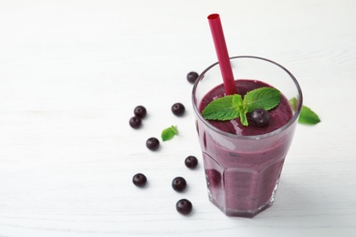 Photo of Glass with delicious acai smoothie on table