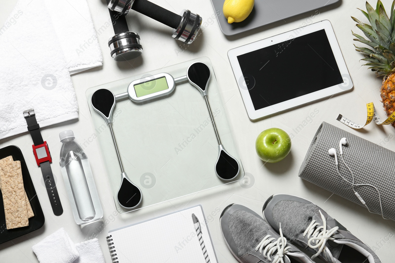 Photo of Flat lay composition with sport equipment and scales on light background. Weight loss