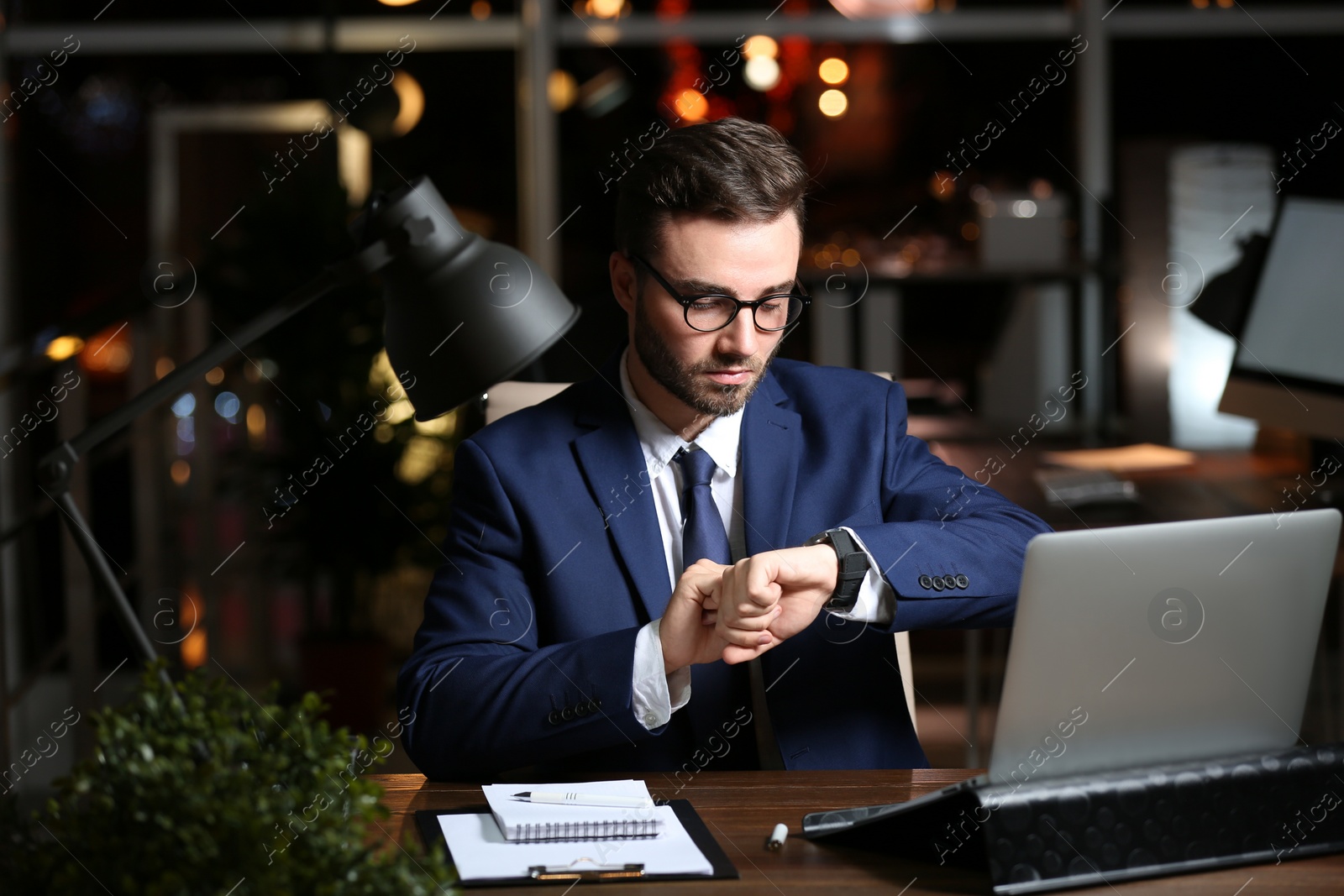 Photo of Young man working in office at night