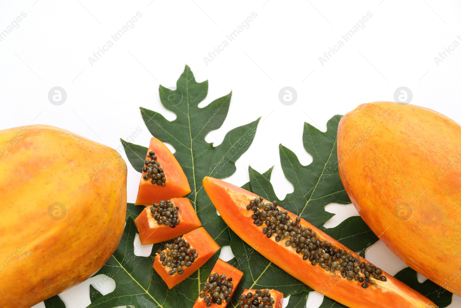 Photo of Fresh ripe cut and whole papaya fruits with leaf on white background. Space for text