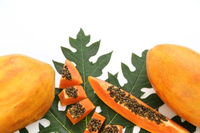 Photo of Fresh ripe cut and whole papaya fruits with leaf on white background. Space for text