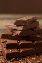 Photo of Pieces of tasty chocolate on wooden table, closeup