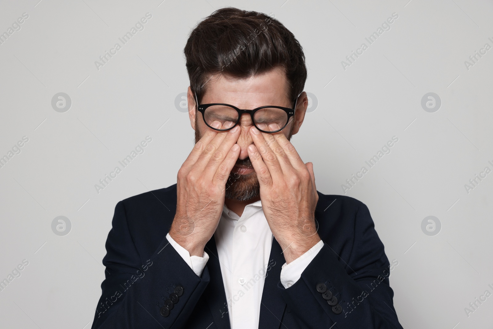 Photo of Man suffering from eyestrain on light grey background