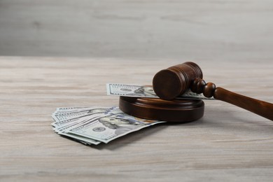 Photo of Judge's gavel and money on wooden table