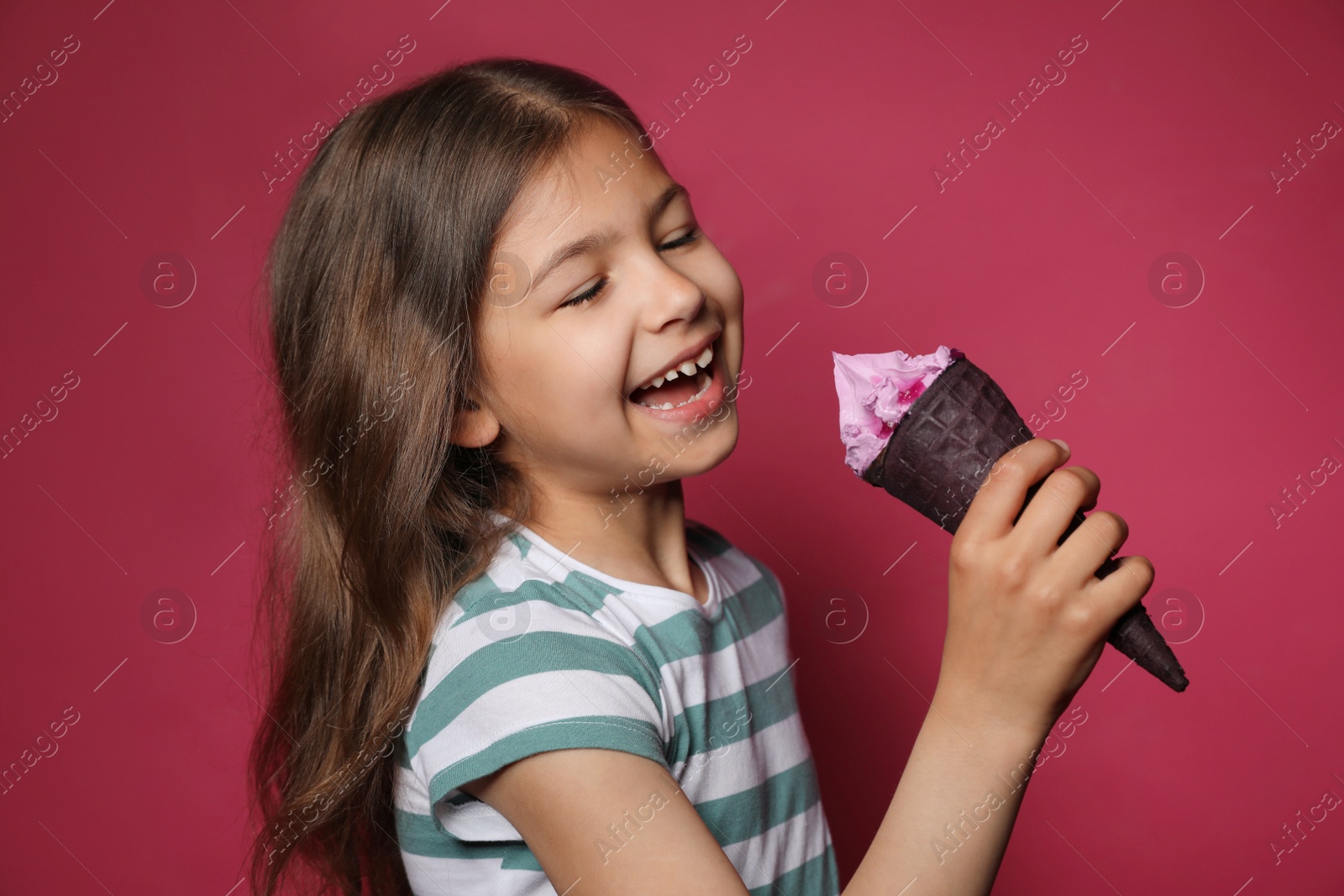 Photo of Adorable little girl with delicious ice cream against color background