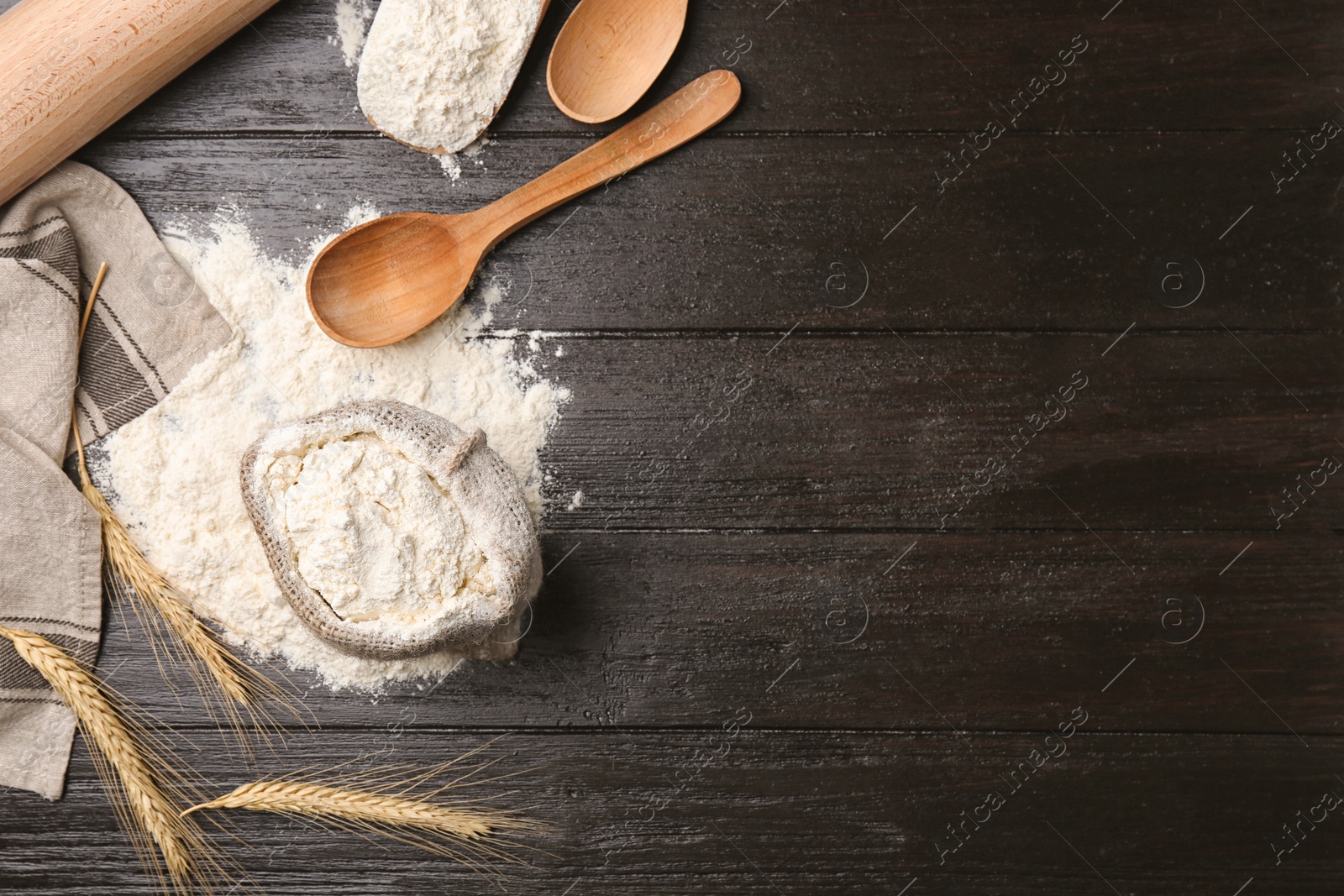 Photo of Composition with sack of flour on wooden background