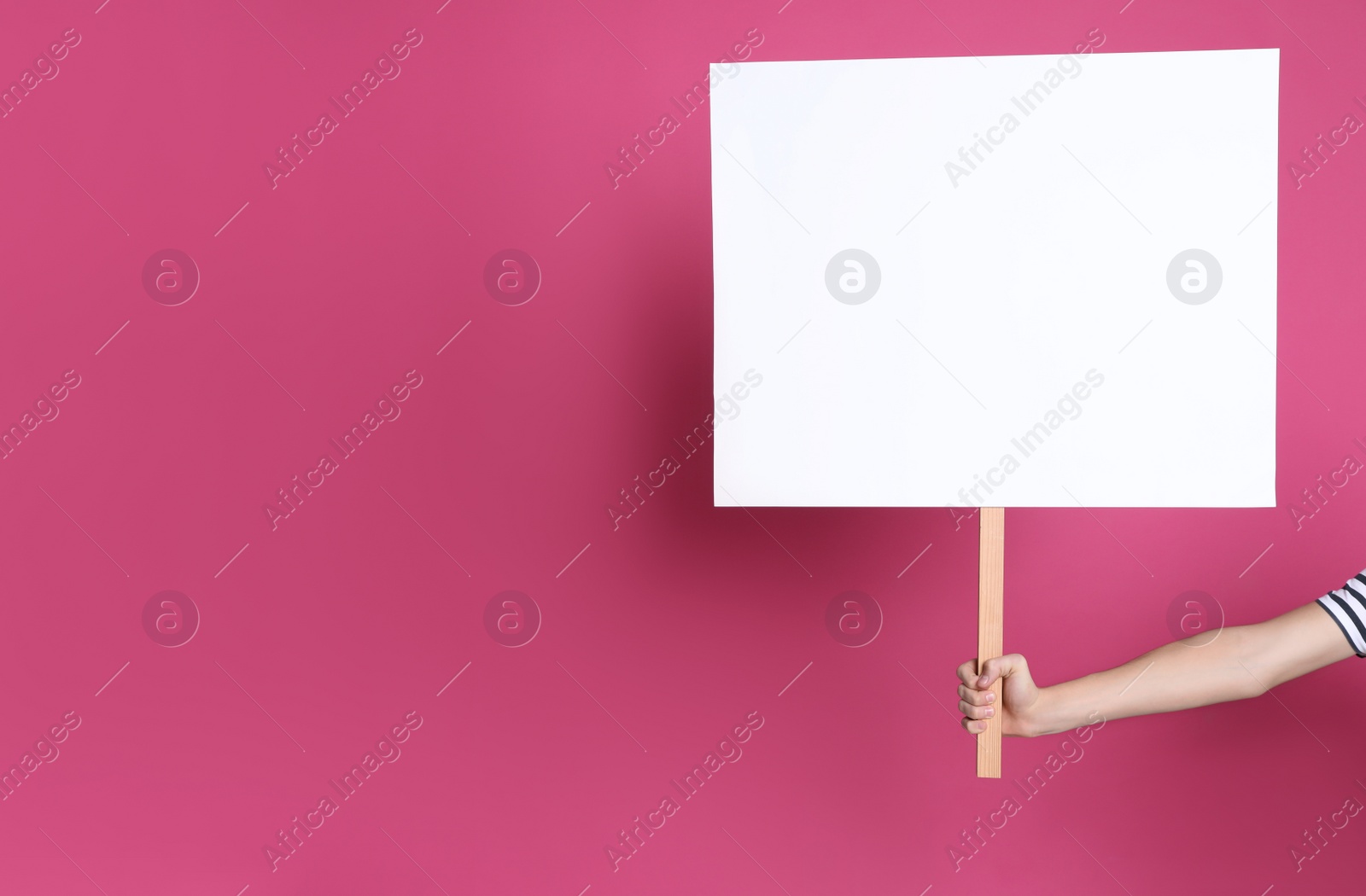 Photo of Woman holding blank sign on pink background, closeup. Space for text