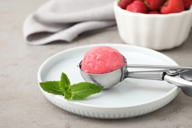 Photo of Scoop of delicious pink ice cream on grey table