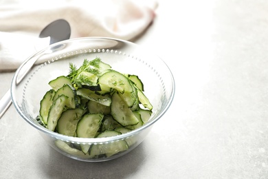 Photo of Delicious cucumber salad with dill in bowl on table. Space for text