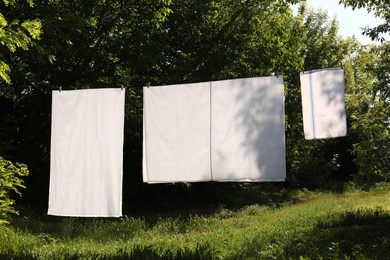 Washing line with clean laundry and clothespins outdoors