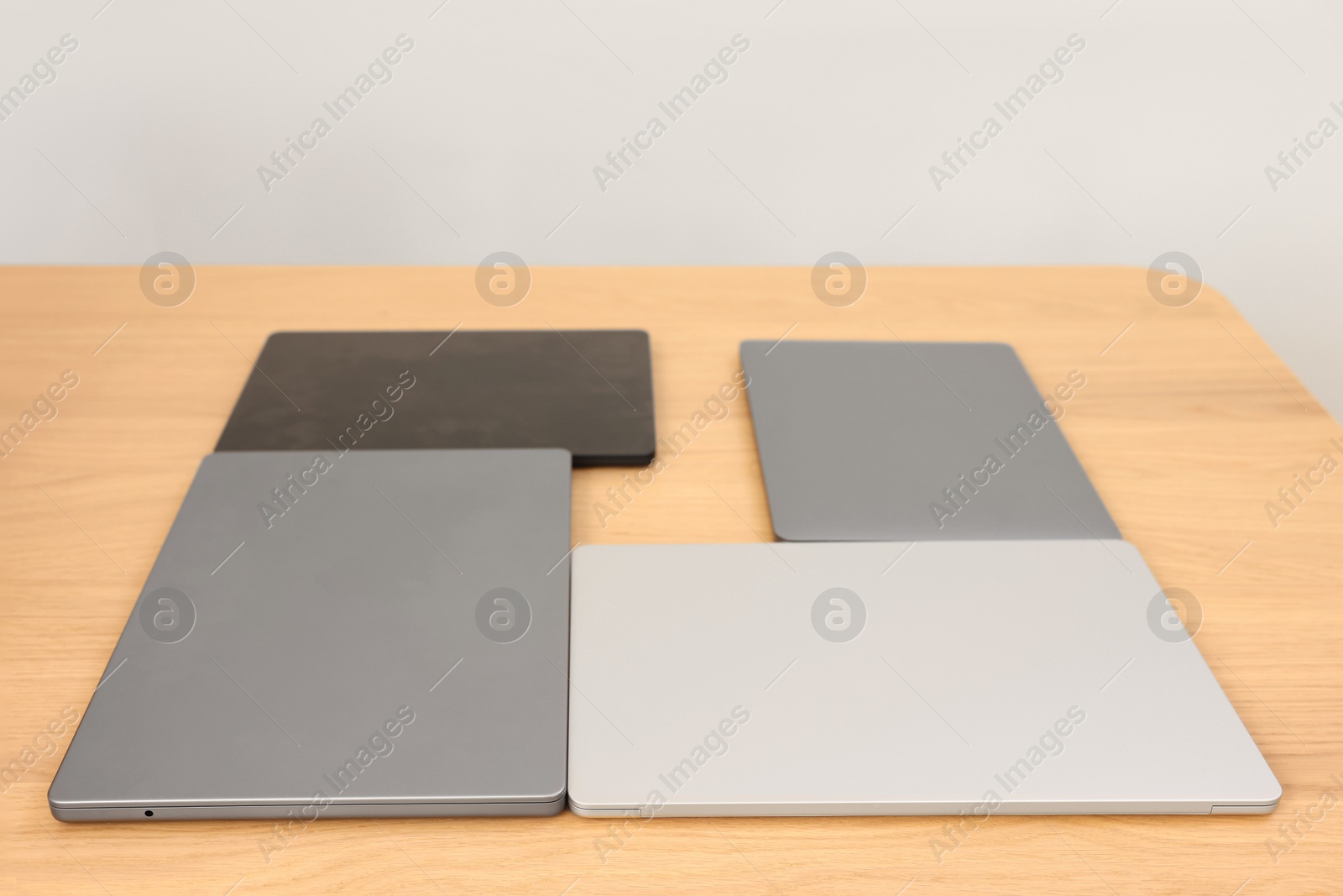 Photo of Different laptops on wooden table. Modern technology