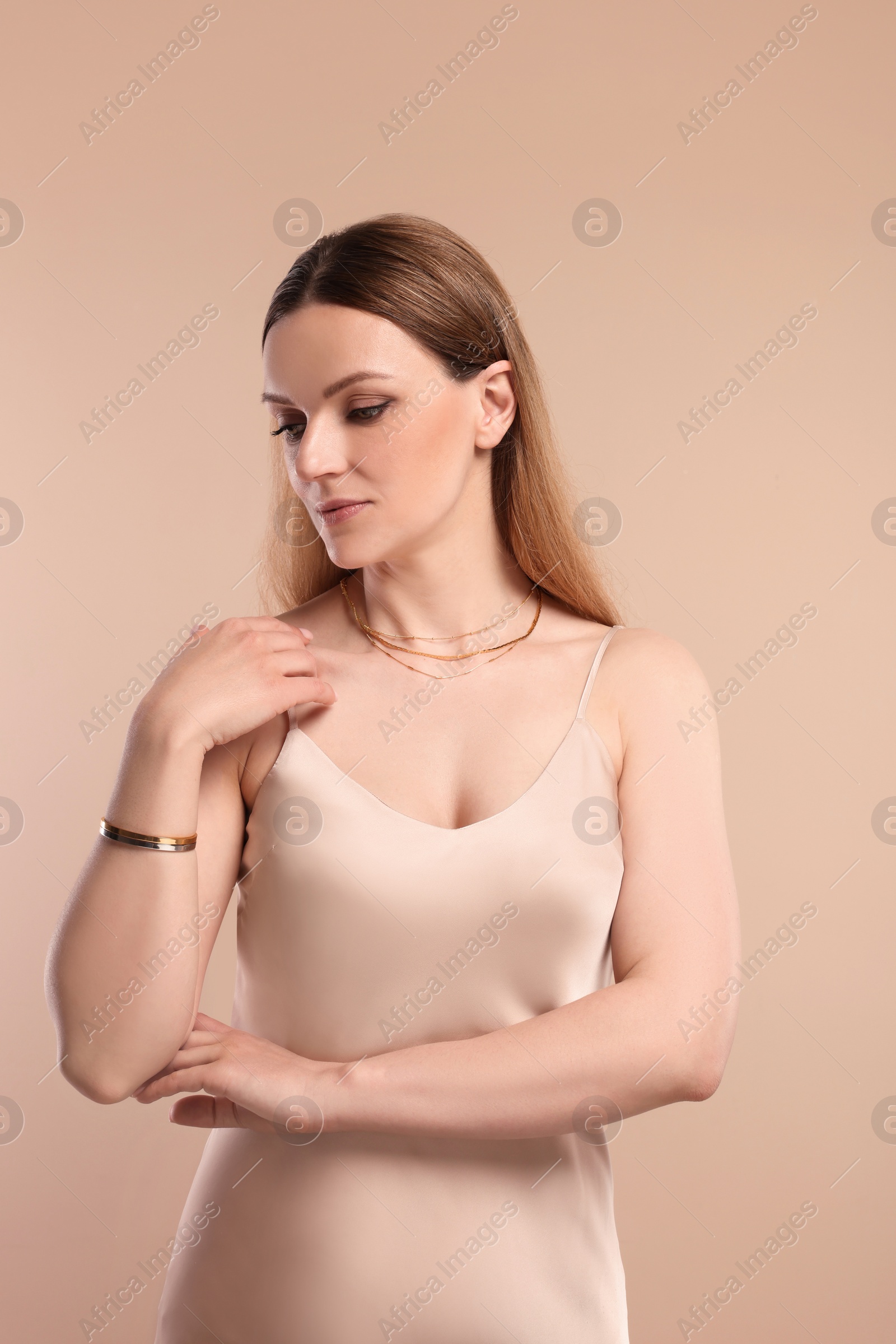 Photo of Beautiful woman with elegant jewelry on beige background