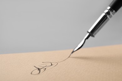 Photo of Signing on sheet of paper with fountain pen, closeup. Space for text