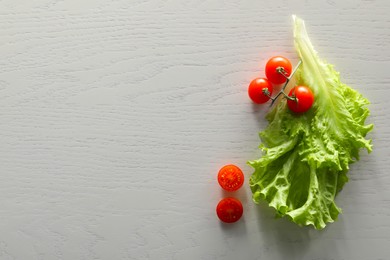 Photo of Food photography. Fresh cherry tomatoes and lettuce on white wooden table, flat lay with space for text