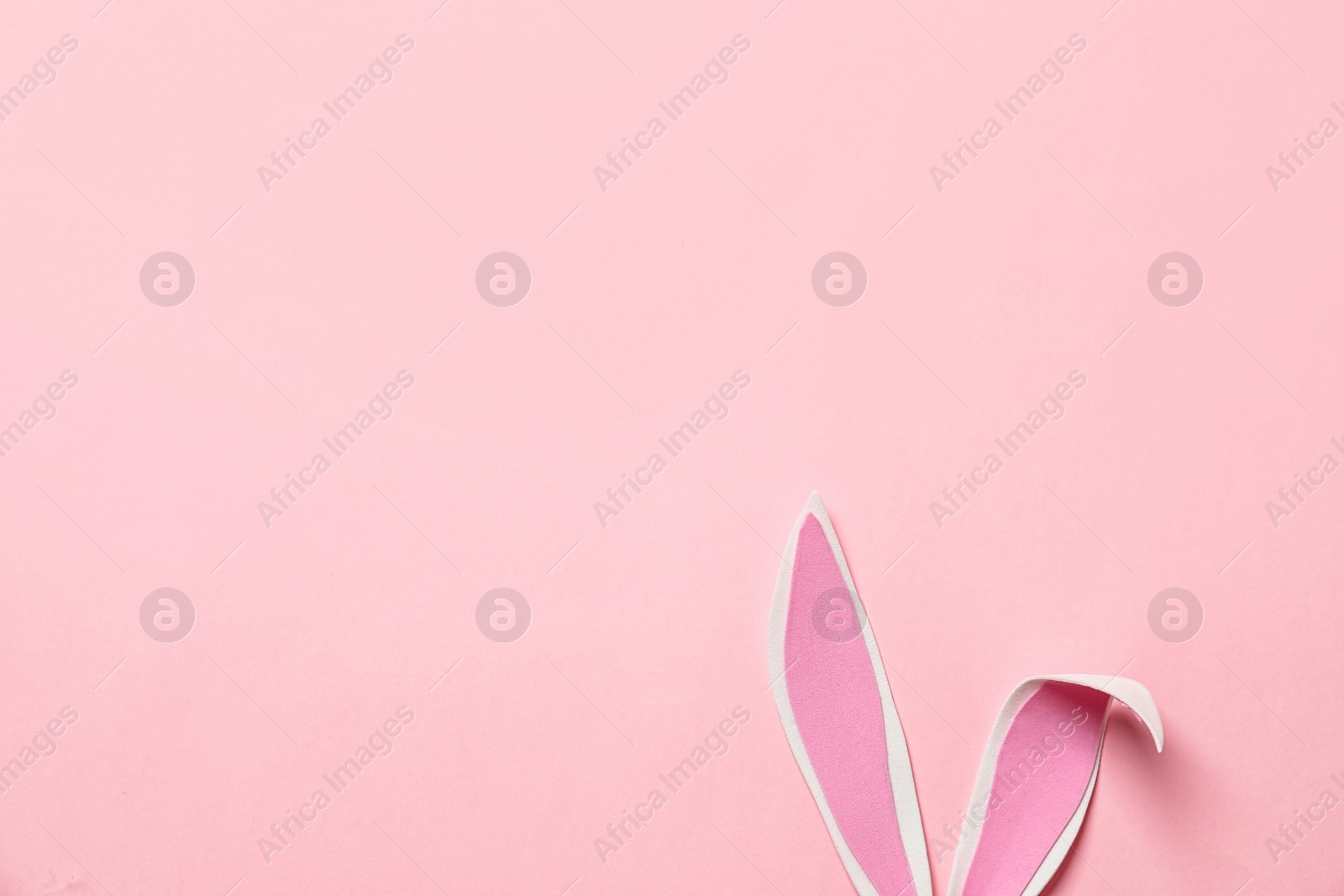 Photo of Funny Easter bunny ears on color background, top view with space for text