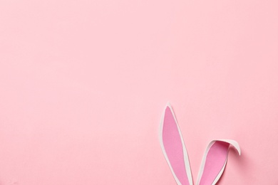 Photo of Funny Easter bunny ears on color background, top view with space for text