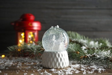 Photo of Magical snow globe with deer and trees on wooden table