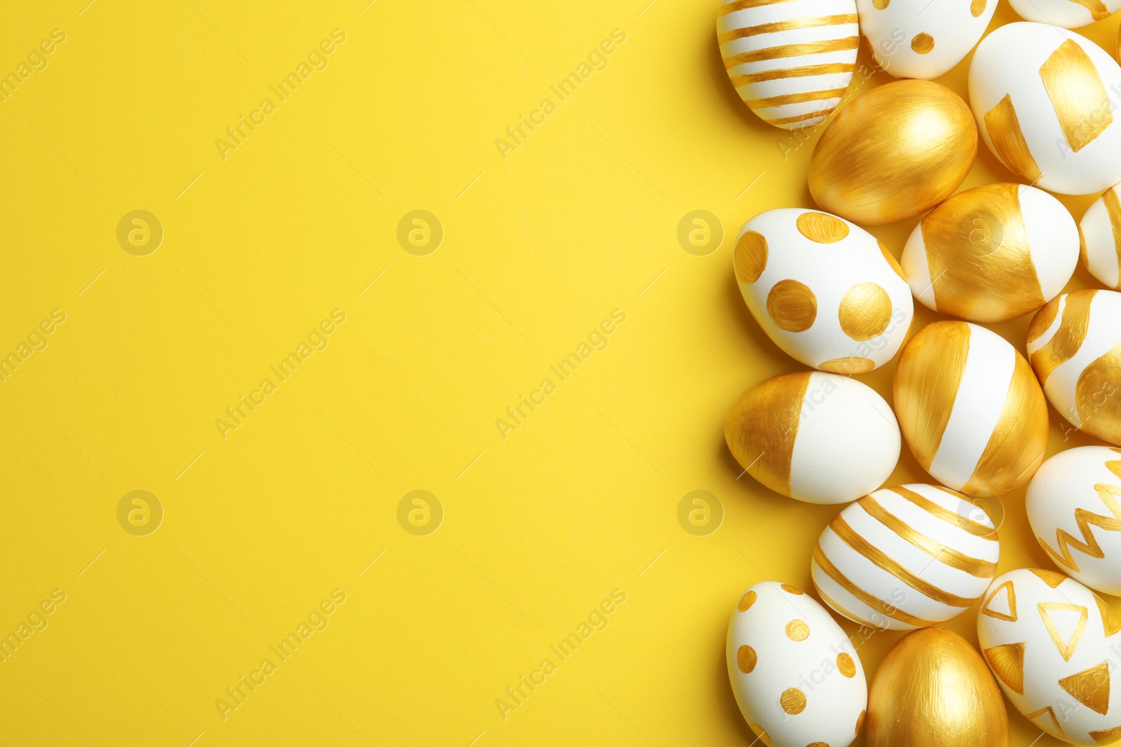 Photo of Traditional Easter eggs decorated with golden paint on color background, top view. Space for text