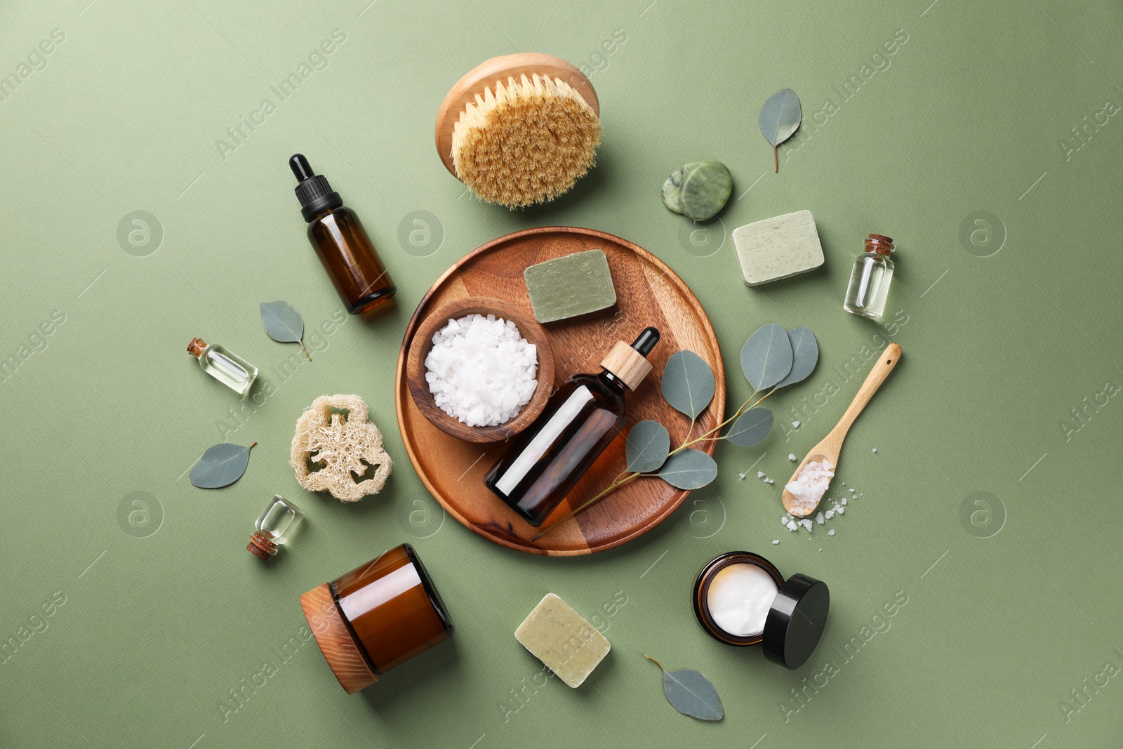 Photo of Flat lay composition with different spa products and eucalyptus branches on olive background