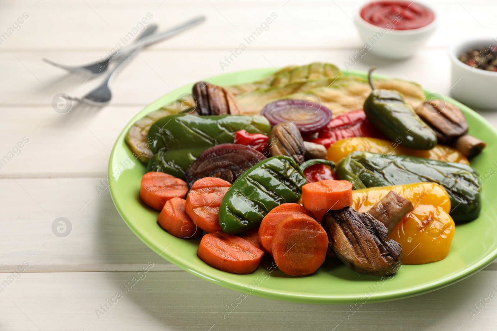 Photo of Delicious grilled vegetables on white wooden table, closeup