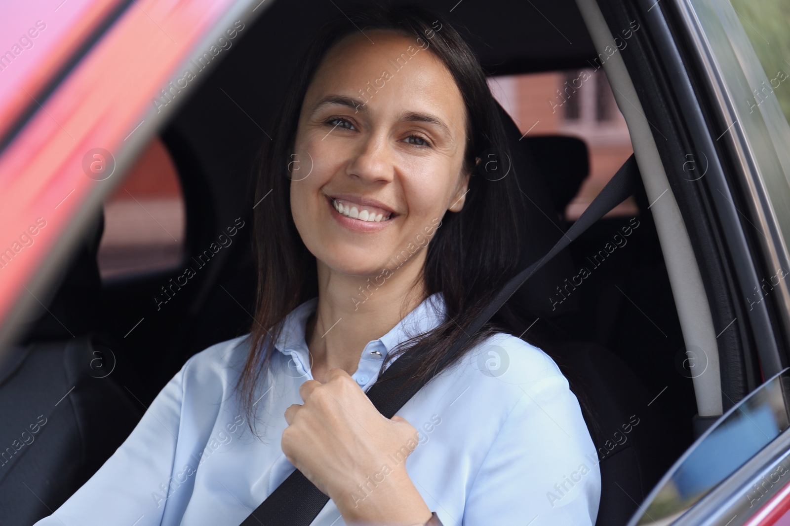 Photo of Woman with fastened safety belt on driver's seat in car