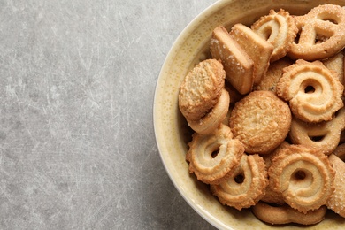 Photo of Bowl with Danish butter cookies on grey background, top view. Space for text