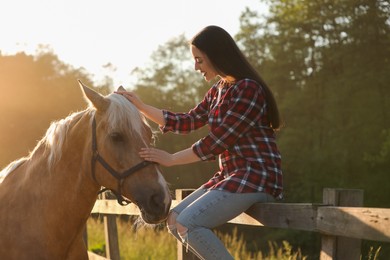 Photo of Beautiful woman with adorable horse outdoors. Lovely domesticated pet