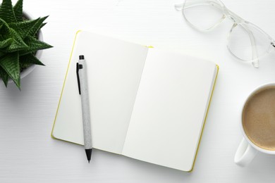 Open notebook, pen, glasses, succulent and cup of coffee on white wooden table, flat lay. Space for text