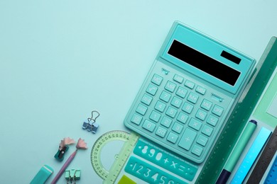 Calculator and stationery on light background, flat lay. Space for text