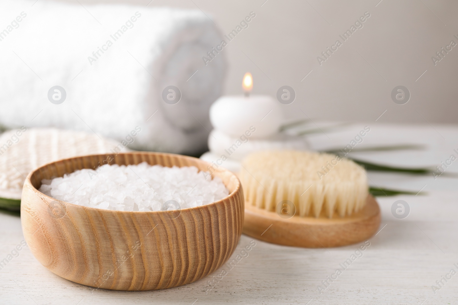 Photo of White sea salt for spa scrubbing procedure on wooden table