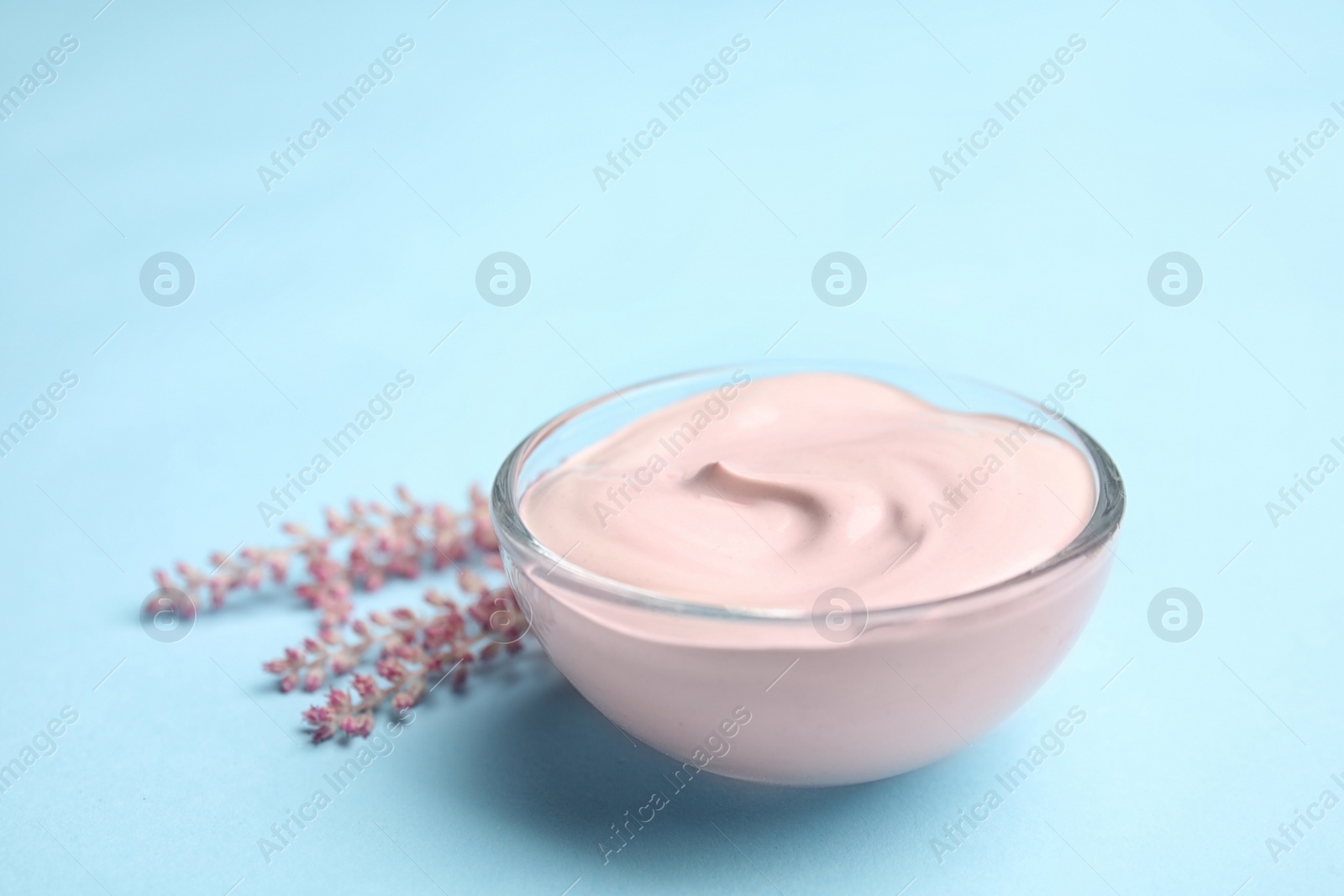 Photo of Professional face mask with flowers on light blue background