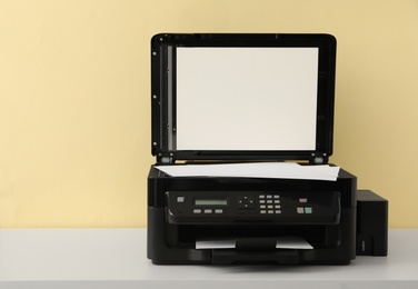 Photo of Modern printer with paper on white table