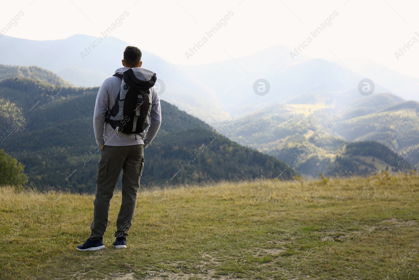 Photo of Man with backpack in mountains, space for text. Tourism equipment