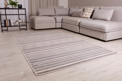 Stylish rug with pattern on floor in living room