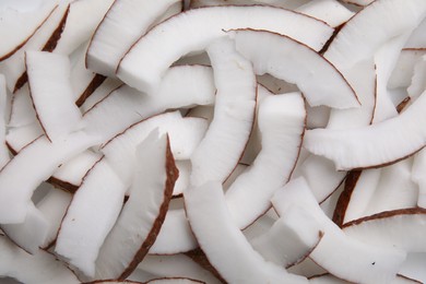 Fresh coconut pieces as background, top view