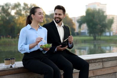 Photo of Smiling business people spending time together during lunch outdoors. Space for text