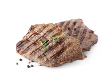 Photo of Delicious grilled beef steaks with thyme and peppers mix isolated on white