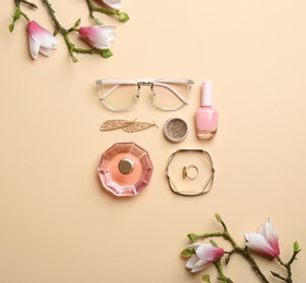Flat lay composition with spring flowers, cosmetics and accessories on beige background