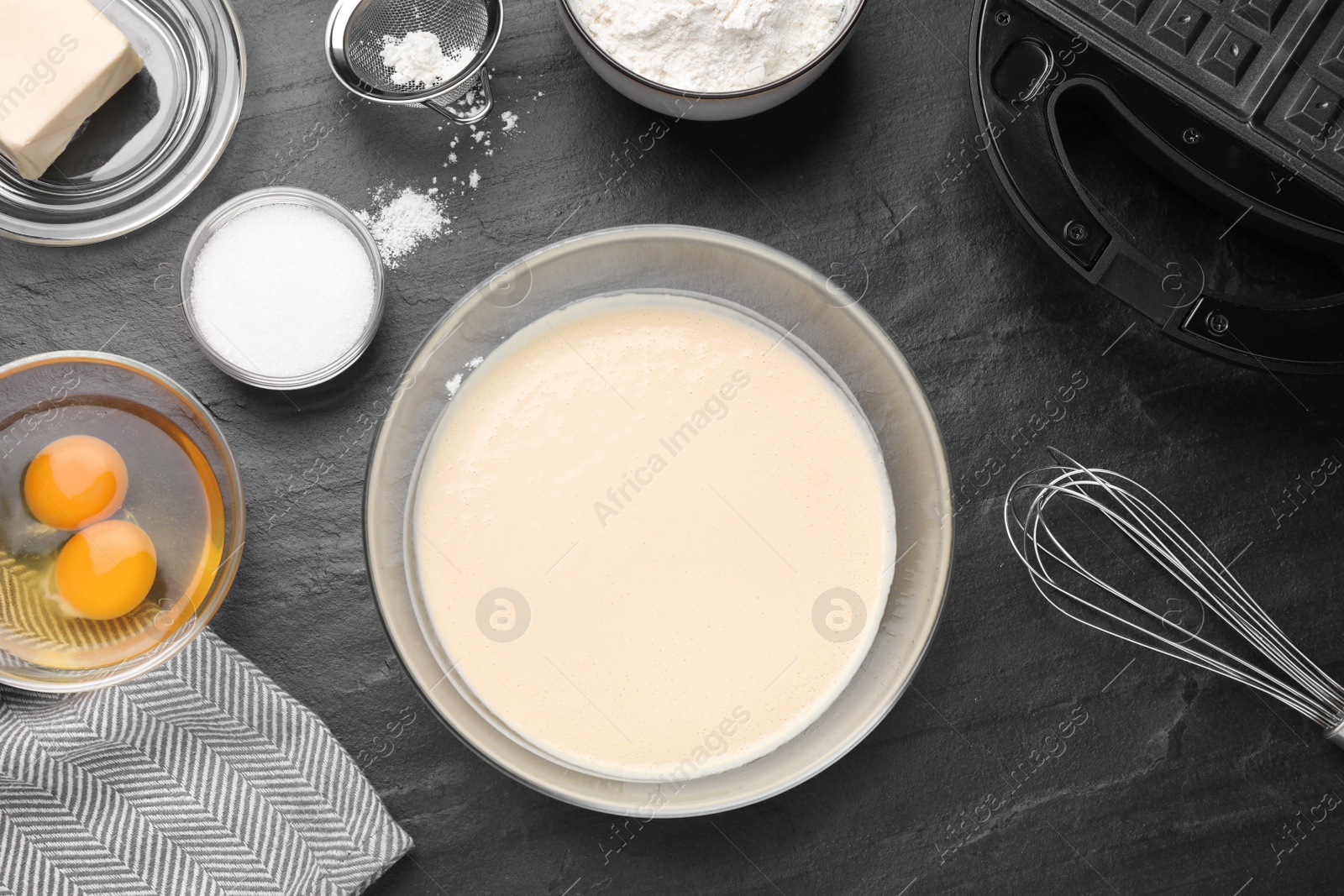 Photo of Flat lay composition with ingredients for cooking Belgian waffles on black table