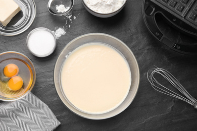 Photo of Flat lay composition with ingredients for cooking Belgian waffles on black table